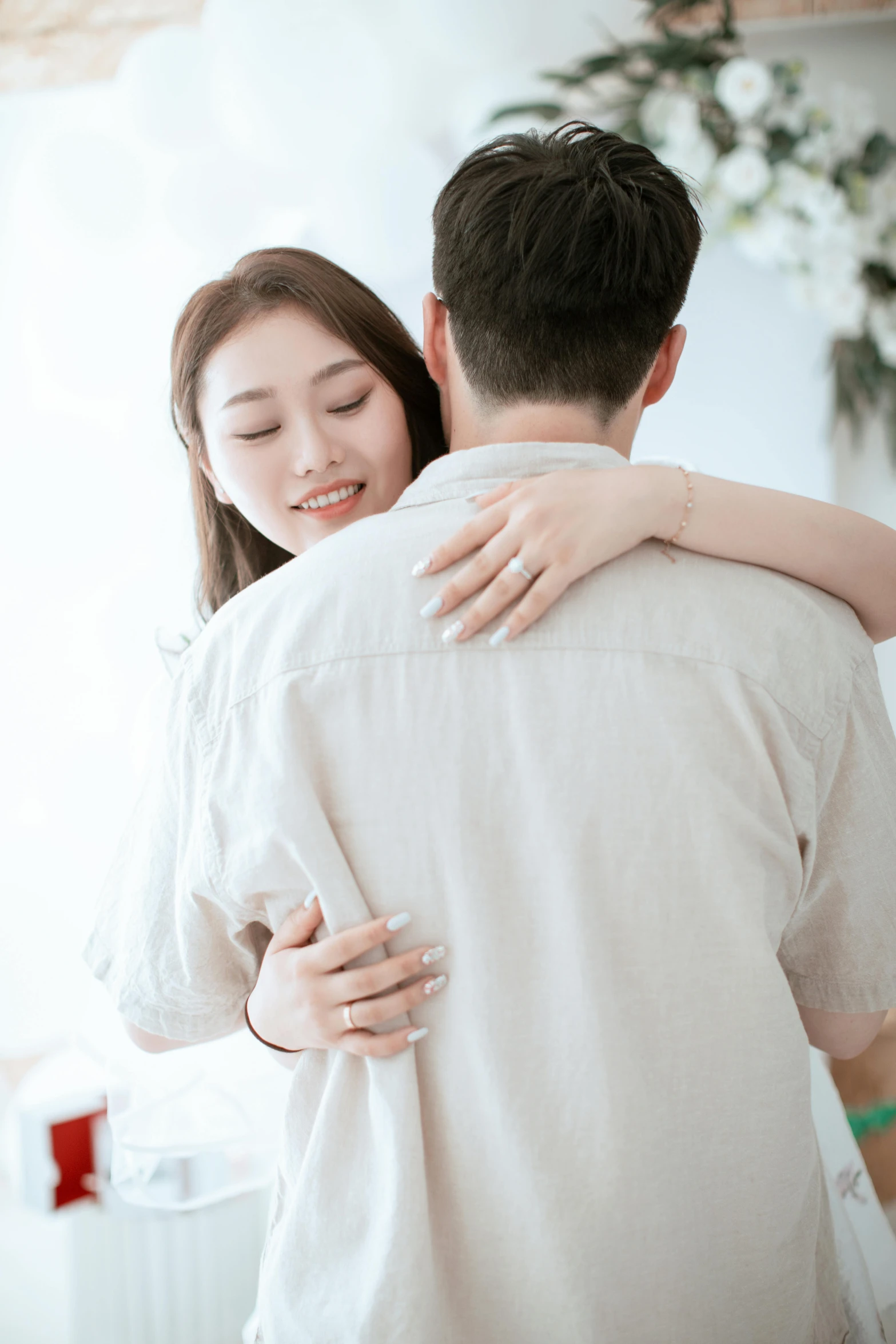 a young woman emcing the arm of a man in a living room