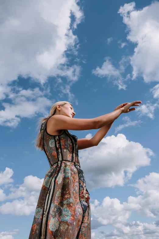 woman in a dress reaching out to catch a frisbee