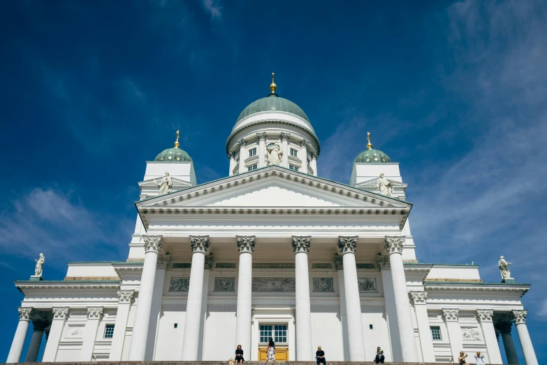 two people standing outside of a tall building with a domed roof