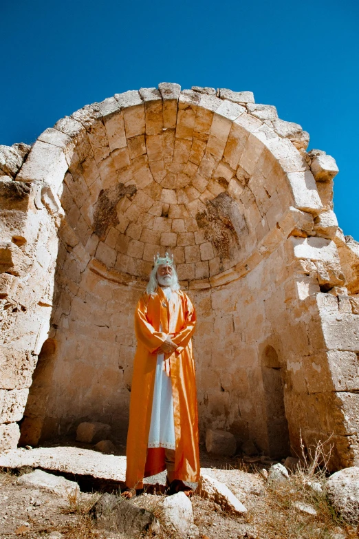 an image of a statue of a monk that is wearing an orange robe