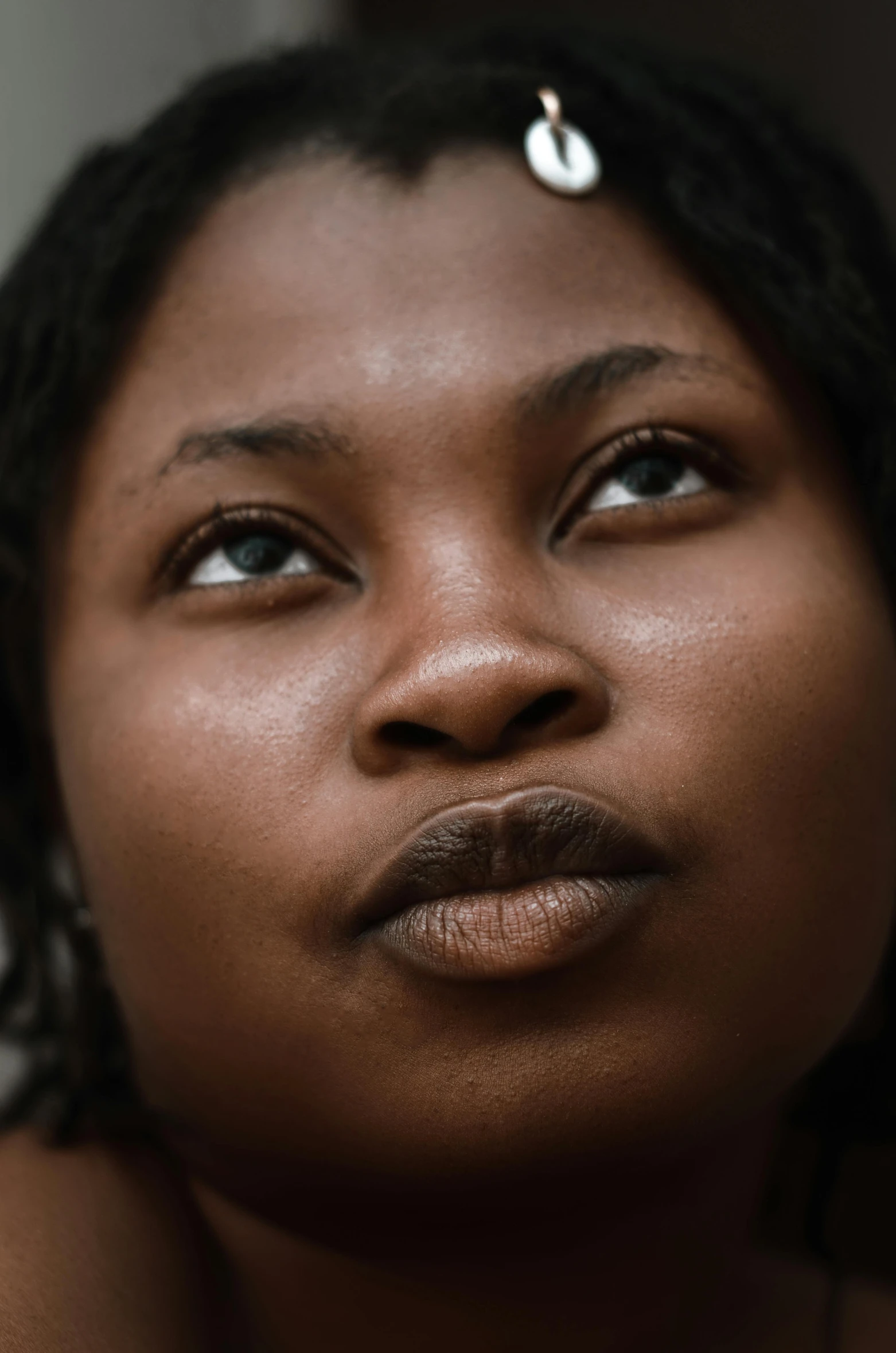 a woman looks up while wearing ear rings