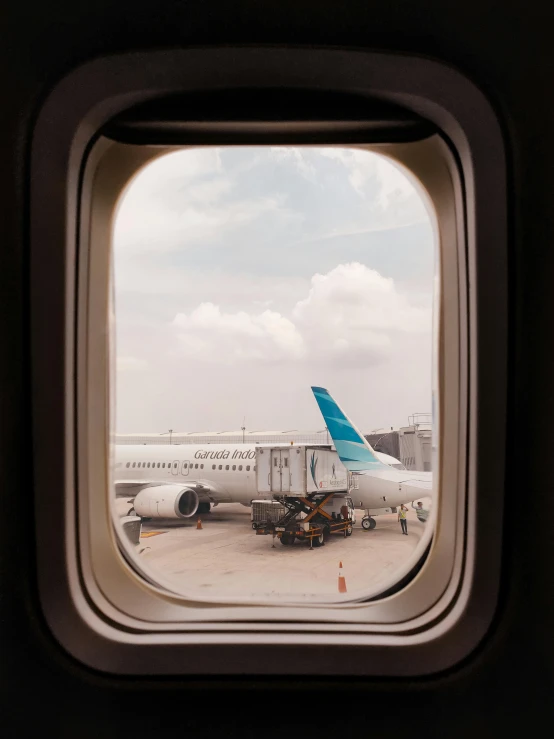 a view from inside of an airplane window of a plane at an airport