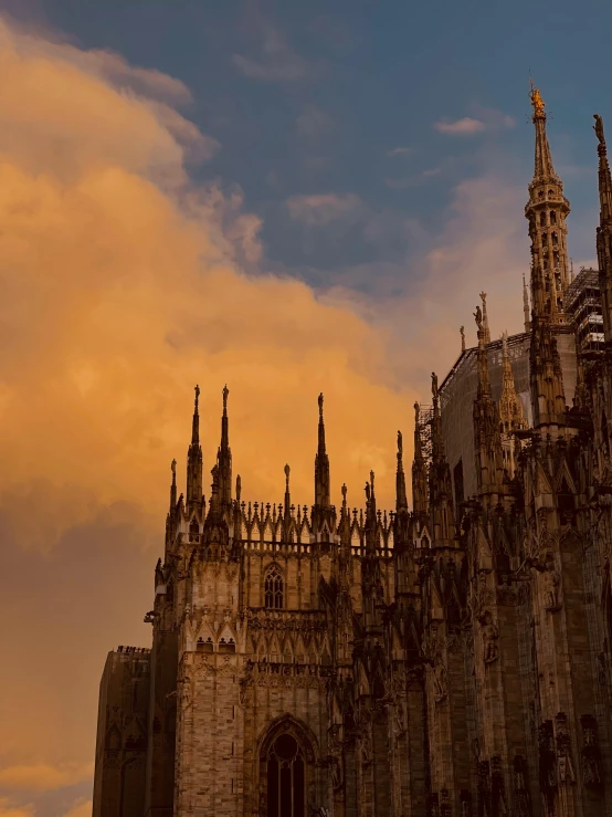 very ornate architecture and large spires are against a bright orange sky