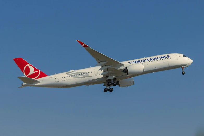 a big plane flying in the air with a bright blue sky background