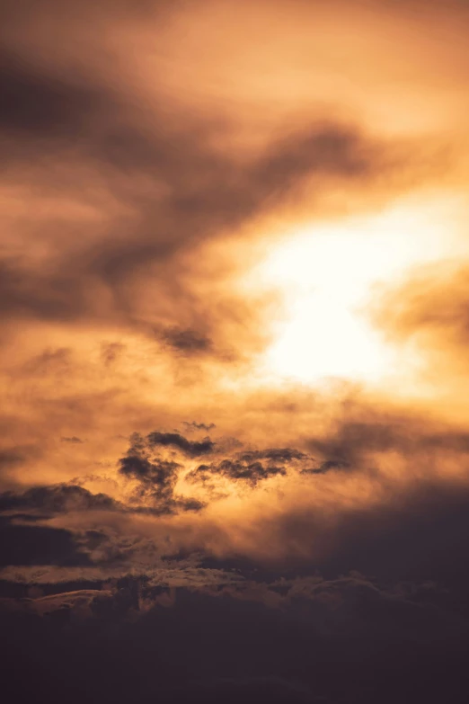 a plane flies by the sun in an orange sky