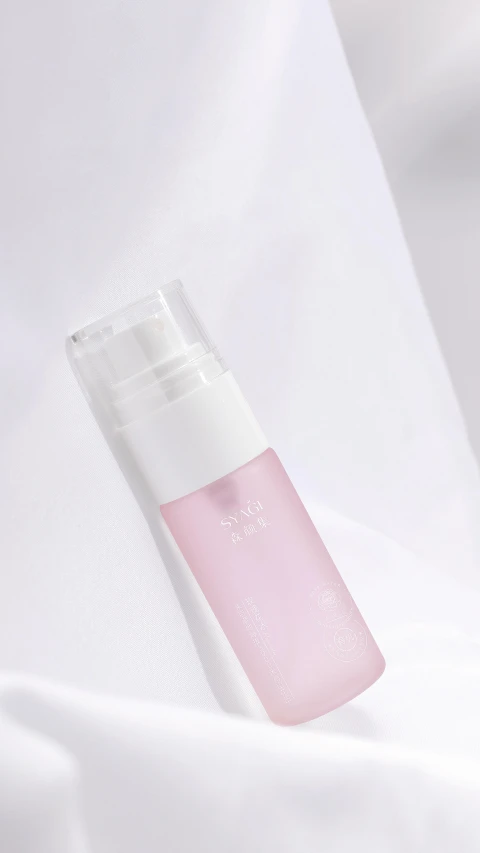 an open tube of clear skin spray on white fabric
