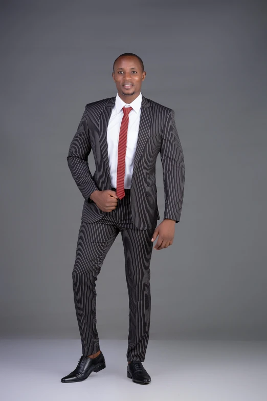 a young man in a business suit poses for a po