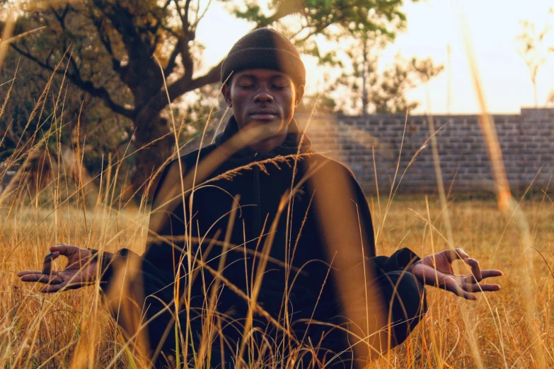 a man is standing in a field with his hands out