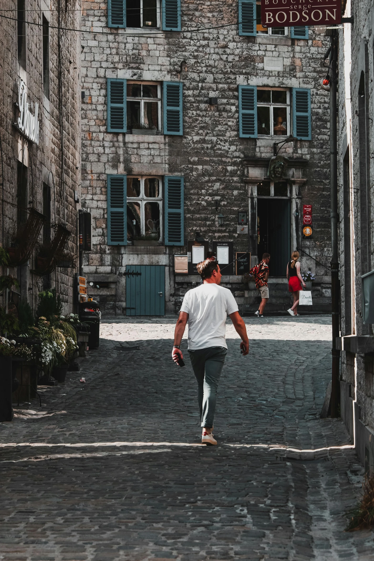 a man is walking down the street toward a brick building