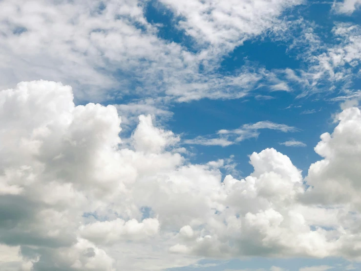 white clouds in the blue sky above an industrial area