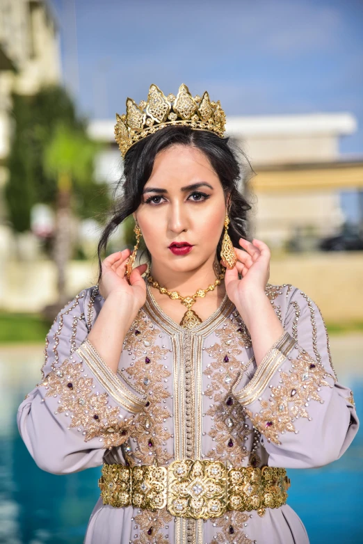 a woman is posing wearing a crown