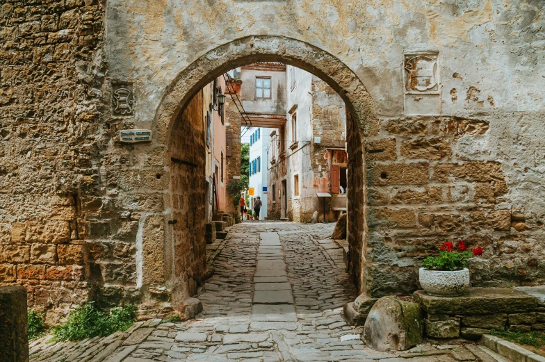 a picture of an alley way with a vase full of flowers