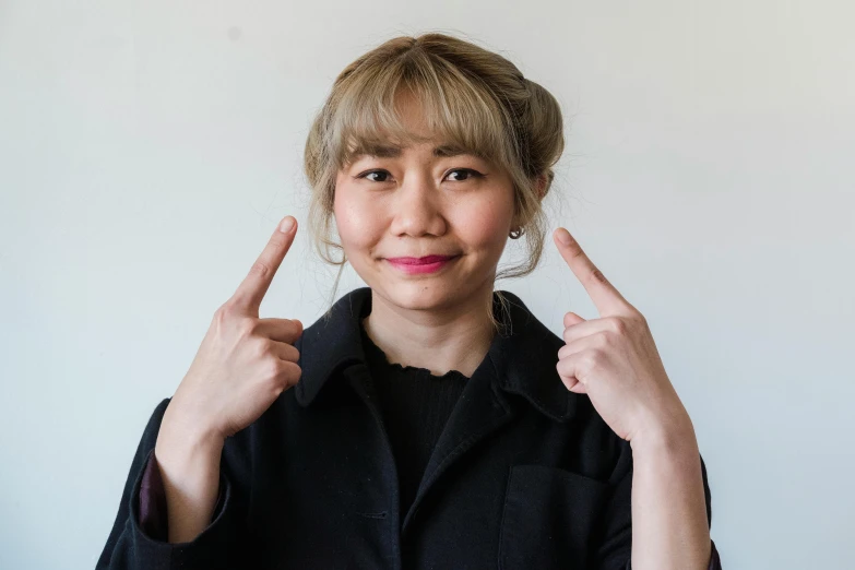 a lady holding up two fingers in front of her face