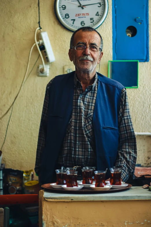 a man standing by a tray full of preserves