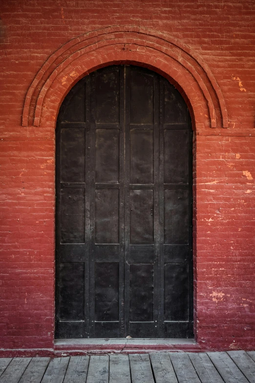 the side of a building with a very tall black door