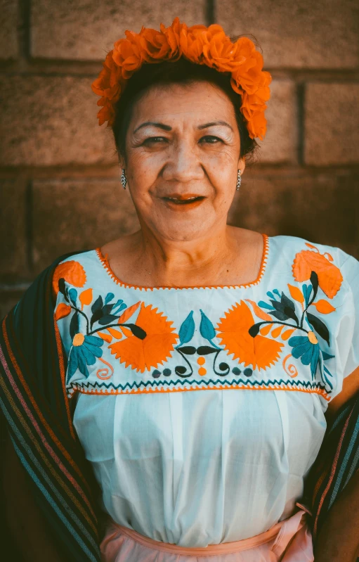 a woman with orange hair is wearing an embroidered top