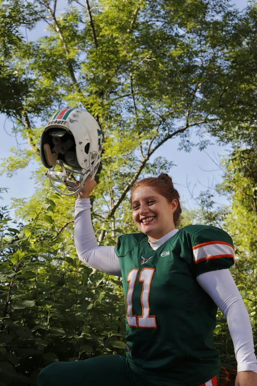 a woman in uniform holds up her helmet