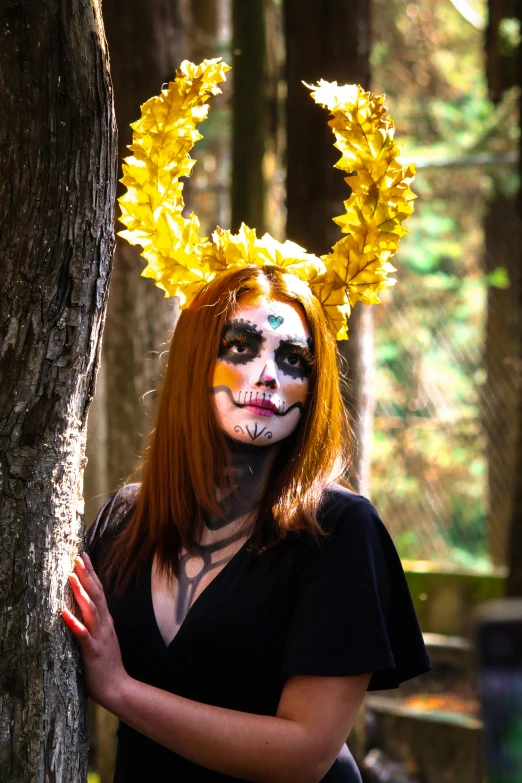 a woman dressed as mime holding her hands near the trunk of a tree