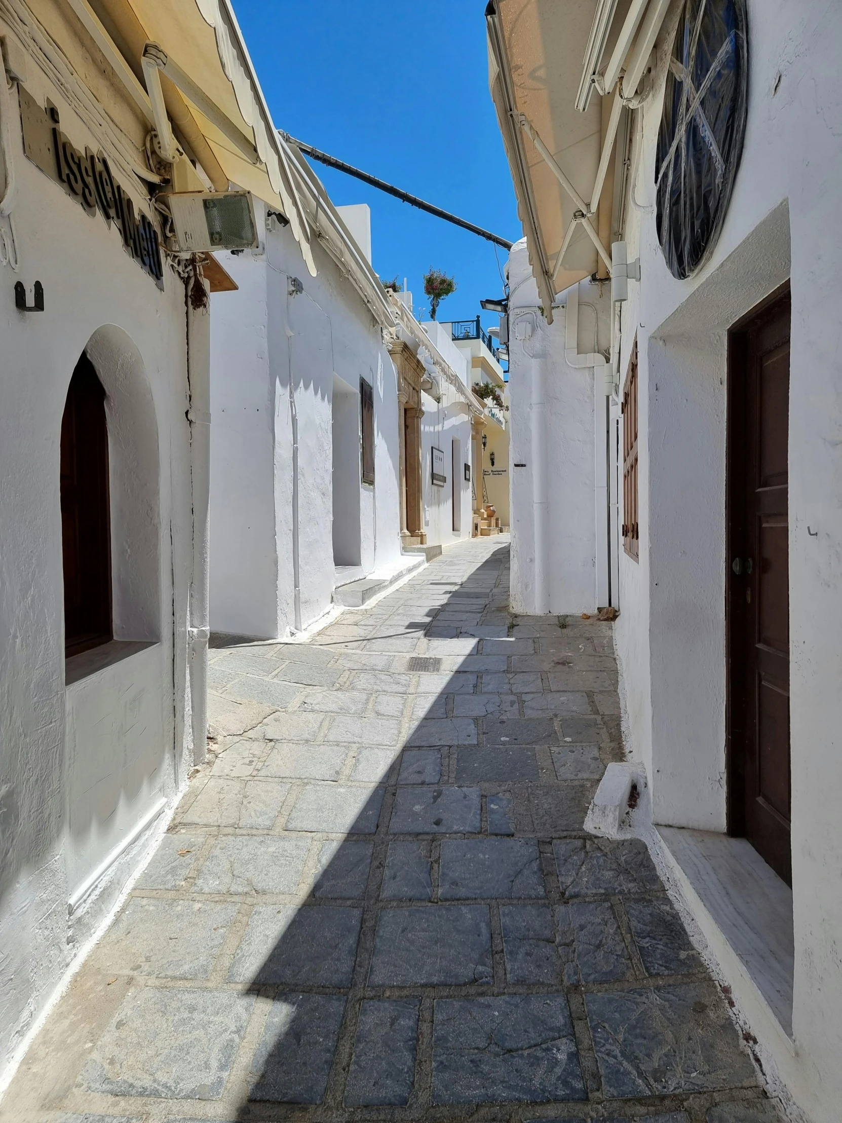 an empty street with cobblestones, arched doorways and doors