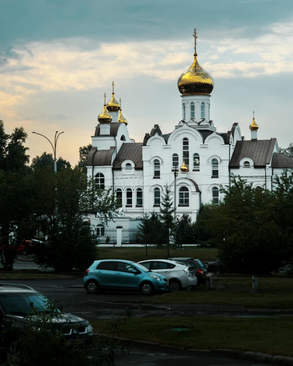 two cars are parked in front of the white church