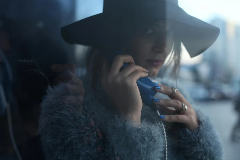 a woman in a hat talks on her cellphone