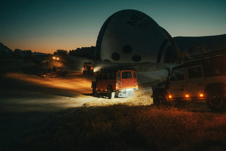 there are trucks that have lights shining in the night