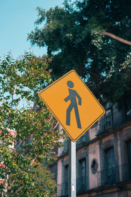 a yellow crosswalk sign showing people walking on it