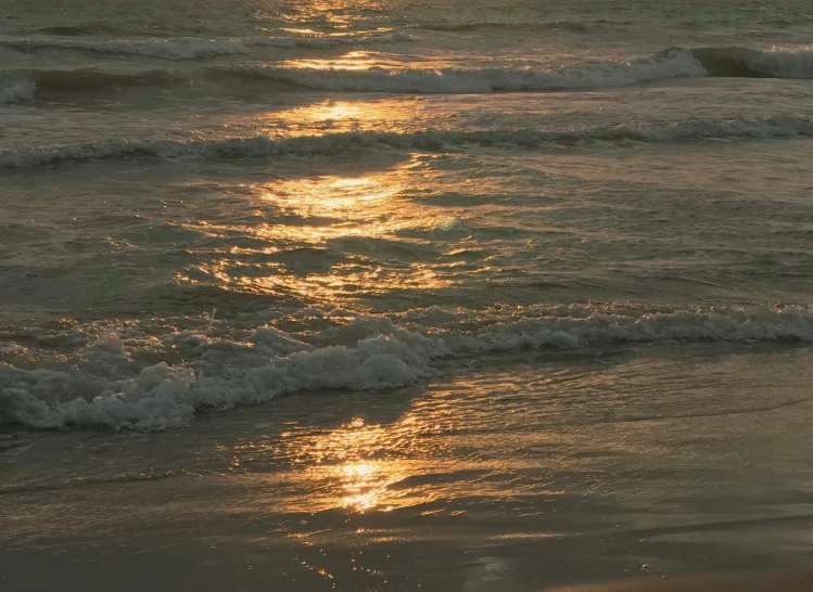 the sun is shining on the beach at night