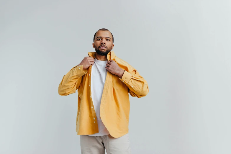 a man in an orange jacket stands on one leg