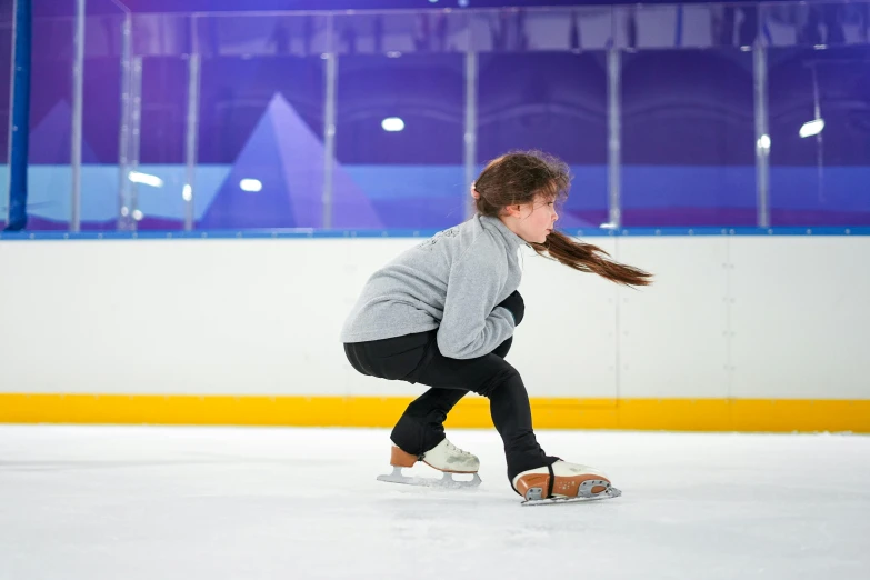 a woman on a skateboard standing next to the ice