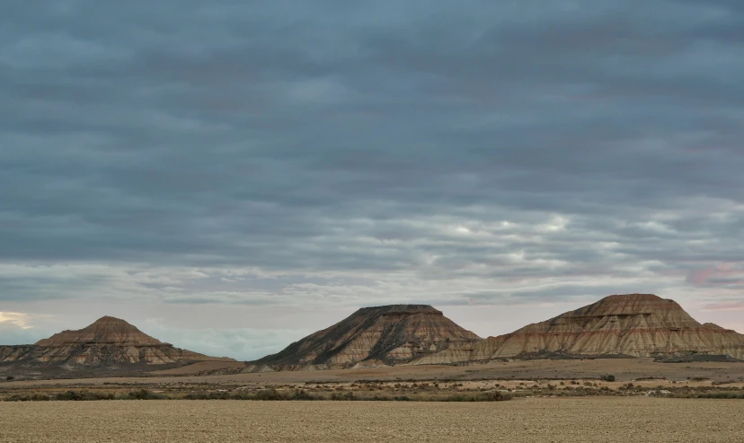 a single kite flying in the sky near a mountain