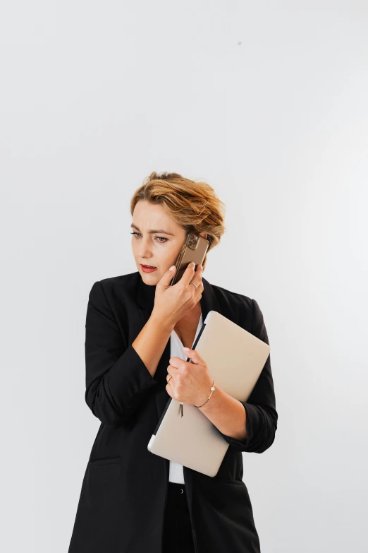 a woman wearing a black jacket and black pants, talking on her cell phone