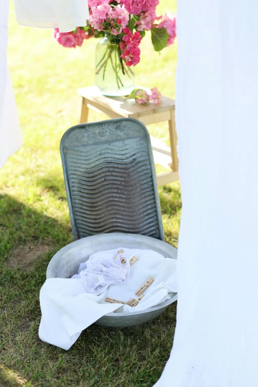 a metal plate sitting next to a chair near flowers