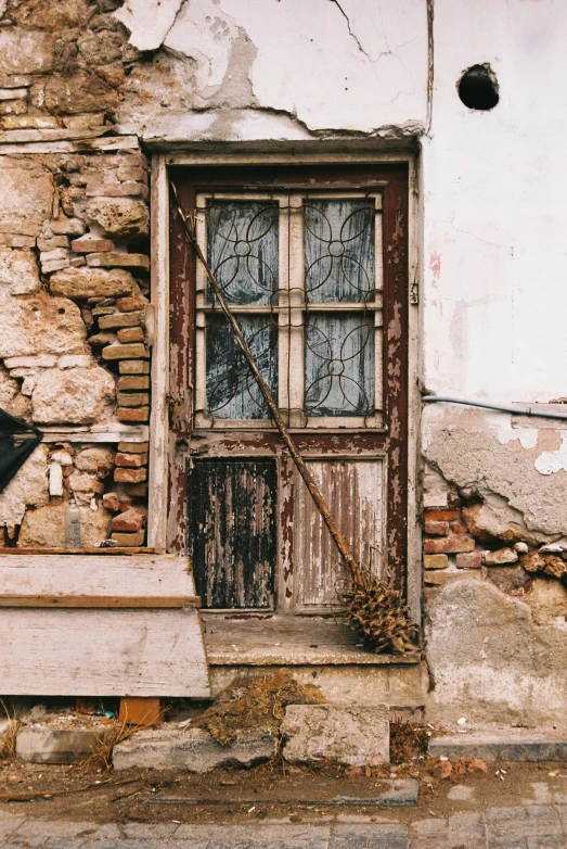 a dirty doorway with an old wooden bench in front