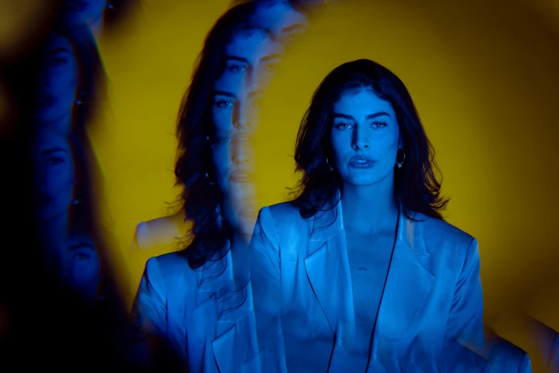 woman standing in front of group of woman dressed in blue, all with hands together