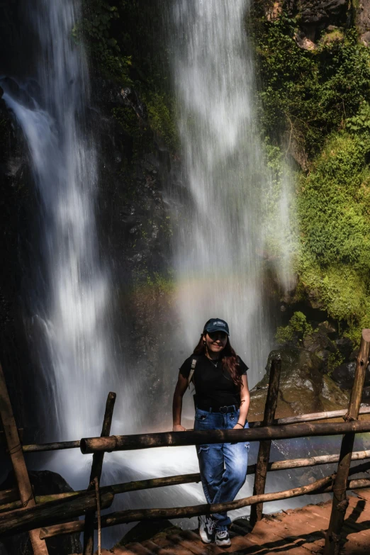 a person standing next to a fence and some water