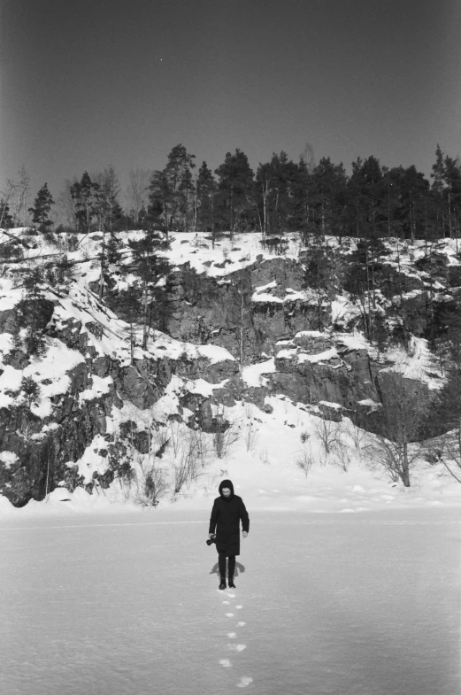 a man is walking across a large field on snow