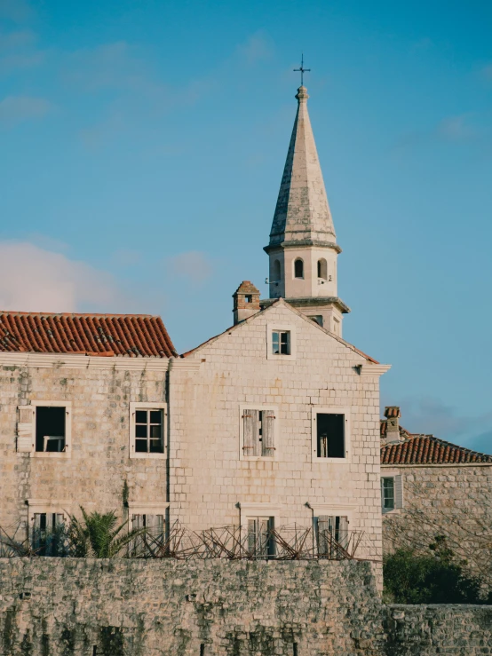 an old white church with a steeple in a city