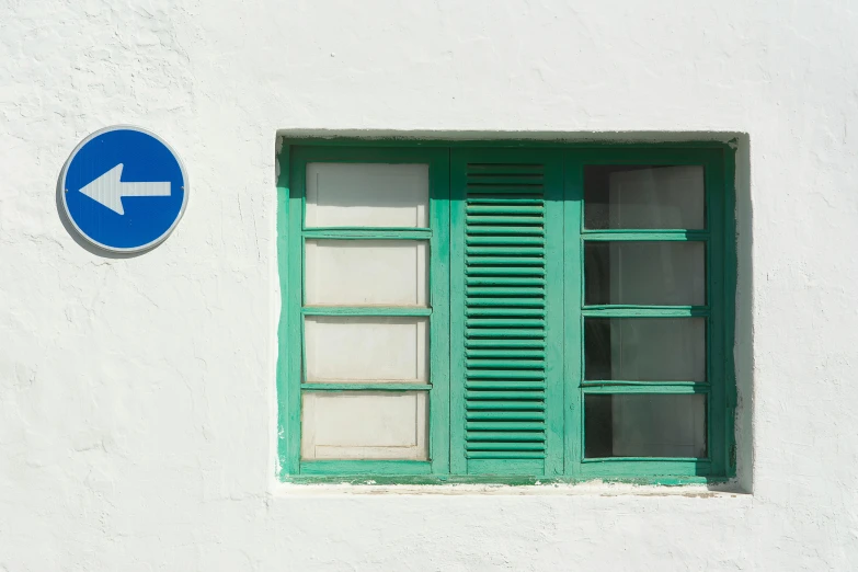 green shutters are on a white building with green windows