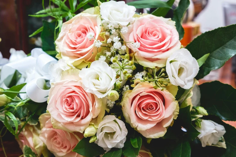 a bunch of pink roses on top of a wooden table