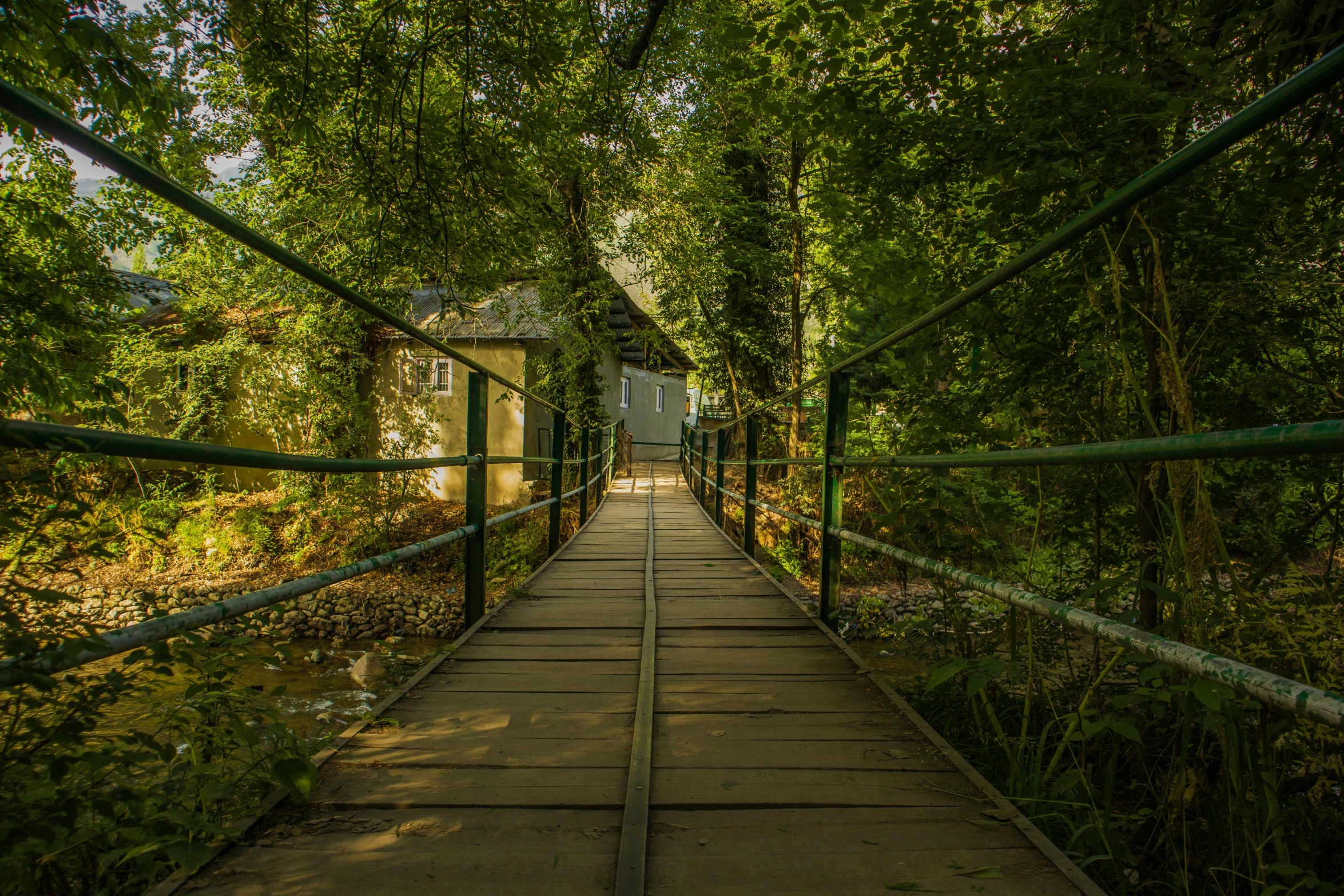 a very narrow bridge that leads to a house