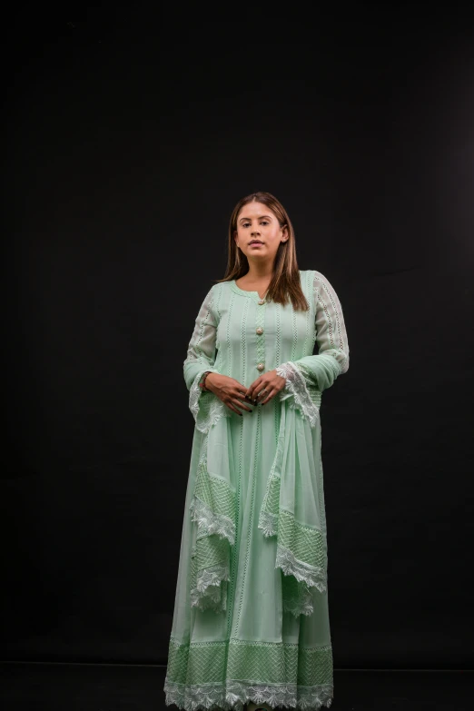 a woman is standing in an unusual green dress