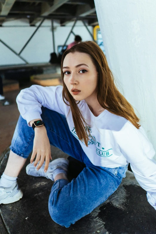 young woman with brown hair sitting on a ledge