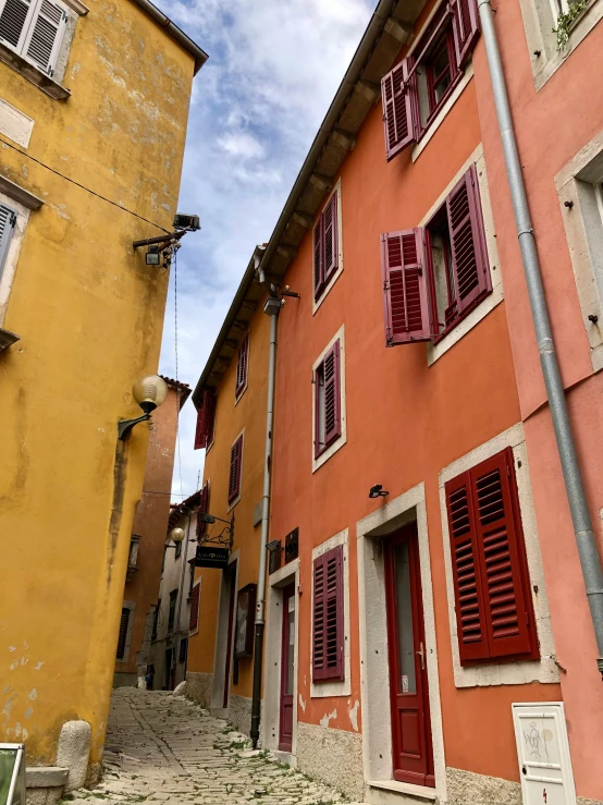 red shuttered doors and windows on an orange building