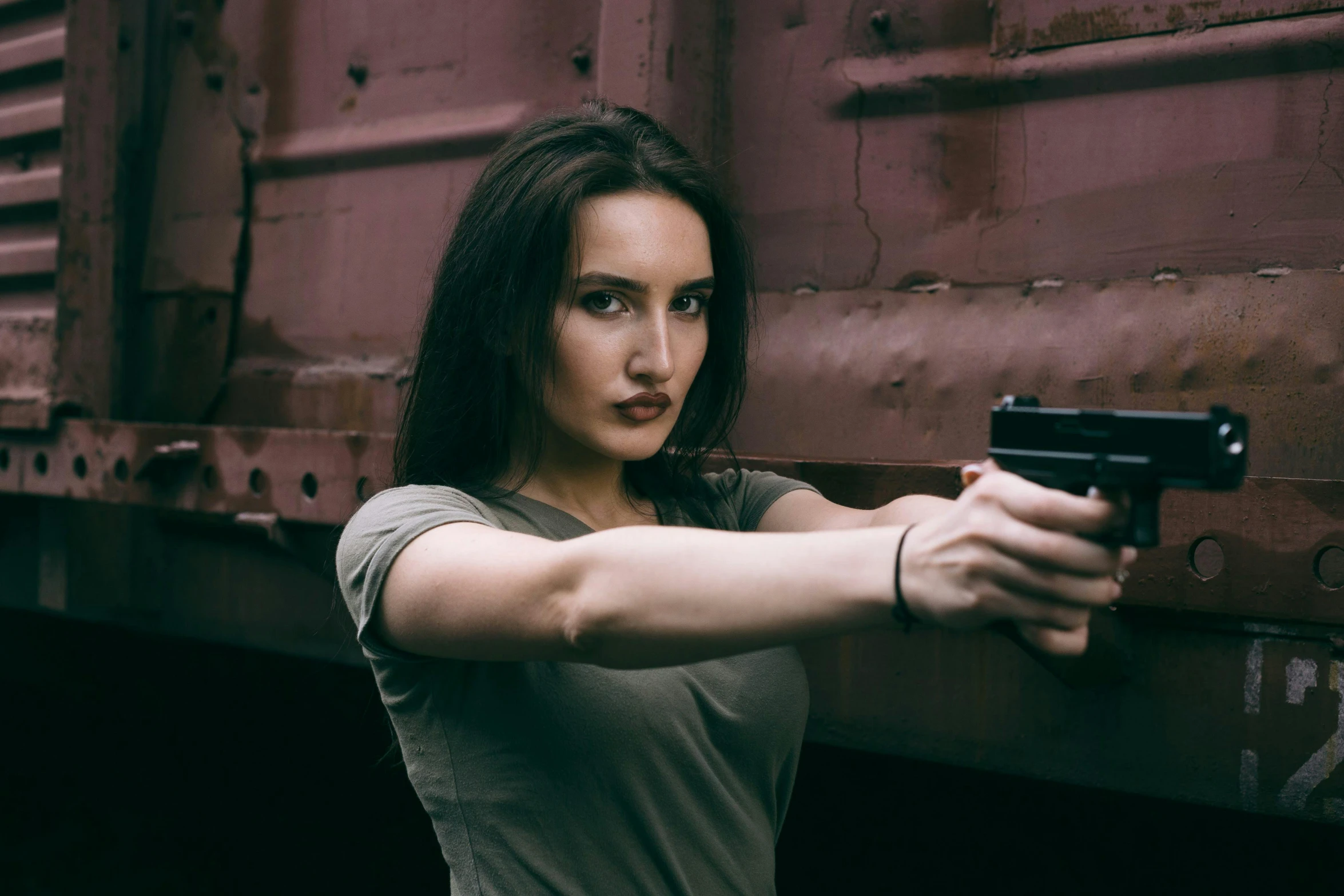 a woman with a gun points at a train