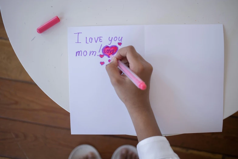 a person making a paper and some type of drawing on a piece of paper