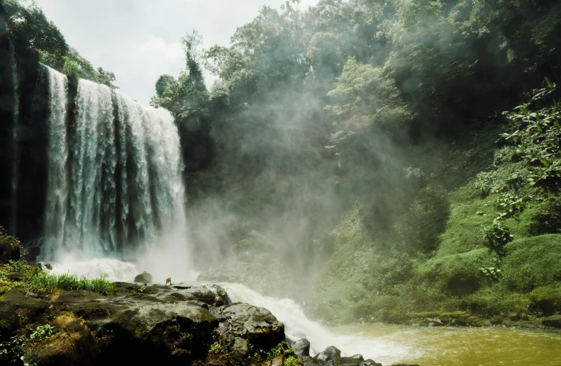 a large waterfall that is in the middle of a forest