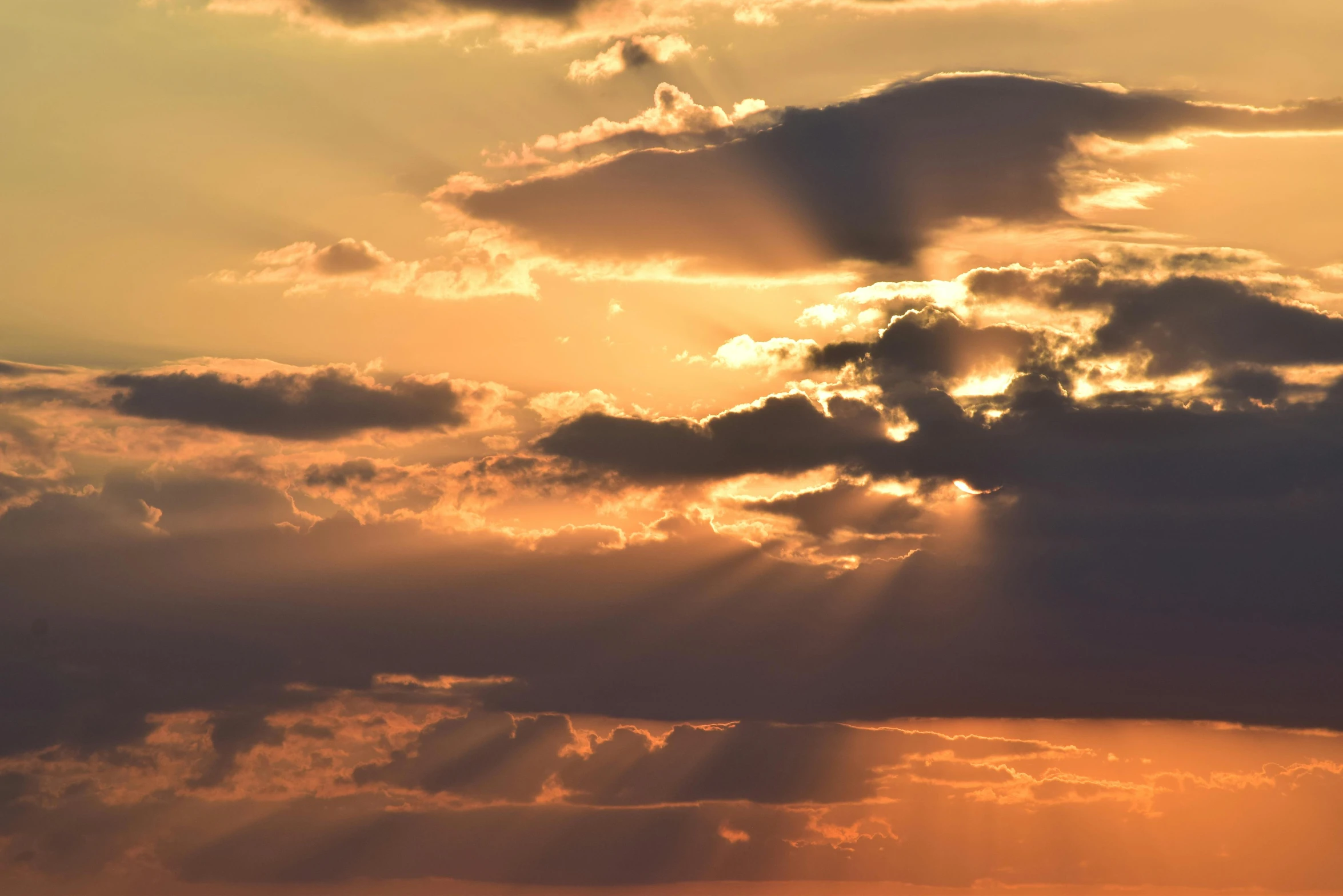 bright sun rays shining through the clouds and building