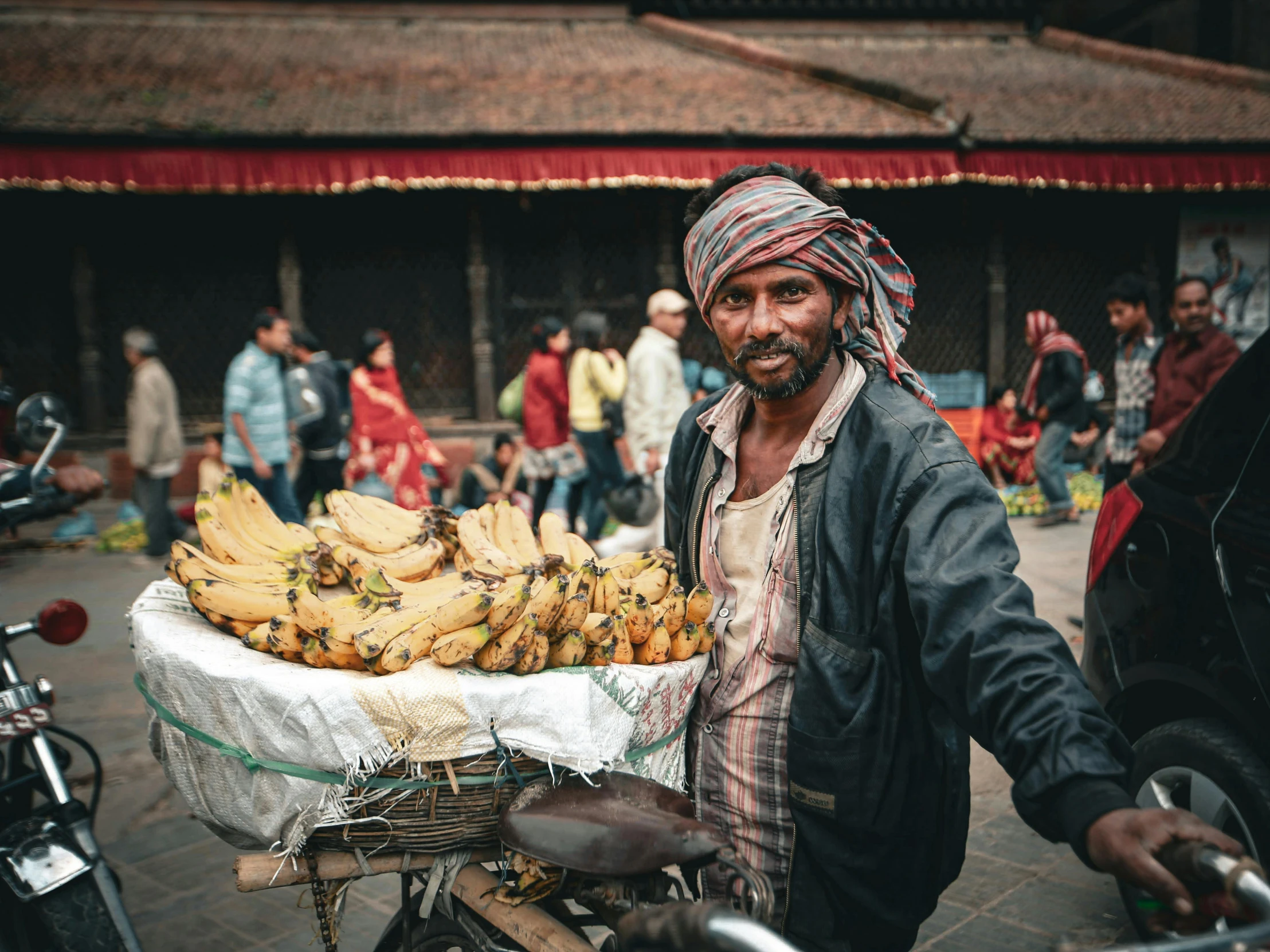 man carrying basket with bananas at outdoor market