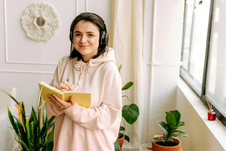 a girl wearing headphones holding a book